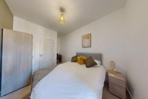 1 dormitorio con 1 cama blanca grande y mesita de noche en Stylish and Modern 3 Bed Home - 5*, en South Shields