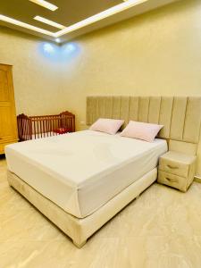 Appartement pour famille avec enfant في الحسيمة: غرفة نوم مع سرير أبيض كبير مع وسائد وردية