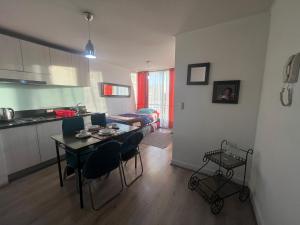 cocina y sala de estar con mesa y sillas en Apartment Relocation 1 Dormitorio, en Santiago