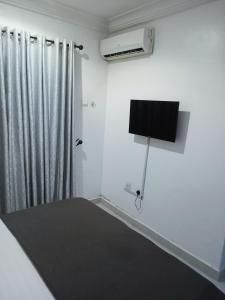 a white room with a radiator and a television at Sommy's place in Abuja