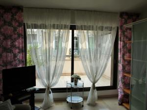 una sala de estar con una gran ventana con cortinas blancas en Gray d' Albion Apartment, en Cannes