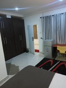 a room with a desk and a table and a door at Sommy's place in Abuja