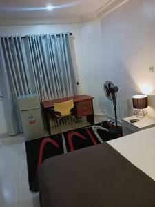 a room with a desk and a table and chairs at Sommy's place in Abuja