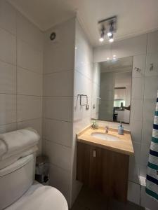 y baño con lavabo, aseo y espejo. en Apartment Relocation 1 Dormitorio, en Santiago