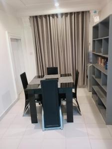 a dining room with a black table and chairs at Sommy's place in Abuja