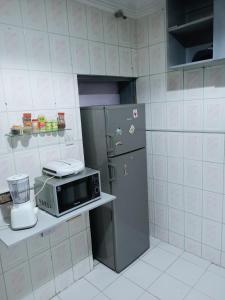 a kitchen with a microwave and a refrigerator at Sommy's place in Abuja