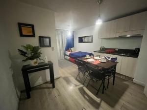 sala de estar con mesa y sillas y cocina en Apartment Relocation 1 Dormitorio, en Santiago