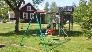 un columpio en un patio con una casa en Idyllisches Bauernhaus in Småland, en Kättilstorp