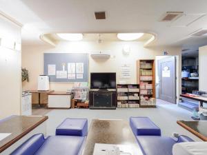 une salle d'attente avec des chaises bleues dans un magasin dans l'établissement Itabashi Hotel Hilltop, à Tokyo