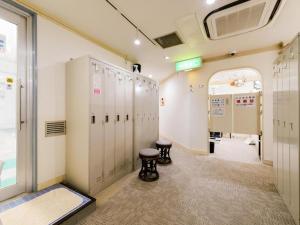 a locker room with lockers and a stool at Itabashi Hotel Hilltop in Tokyo
