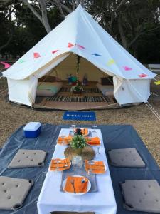 a tent with a table with food on it at Glamping kaki singapore-Standard medium bell tent in Singapore