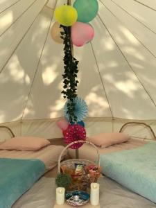 uma tenda com duas camas e um cesto com balões em Glamping kaki singapore-Standard medium bell tent em Singapura