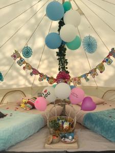 una habitación con una cama con un montón de globos en Glamping kaki singapore-Standard medium bell tent en Singapur