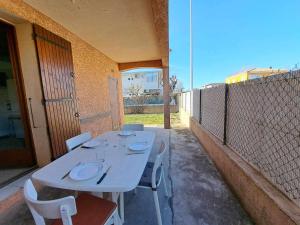 einen weißen Tisch und Stühle auf einer Terrasse in der Unterkunft Appartement Marseillan-Plage, 3 pièces, 6 personnes - FR-1-326-642 in Marseillan