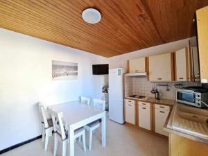 eine Küche mit einem weißen Tisch und einem weißen Kühlschrank in der Unterkunft Appartement Marseillan-Plage, 3 pièces, 6 personnes - FR-1-326-642 in Marseillan