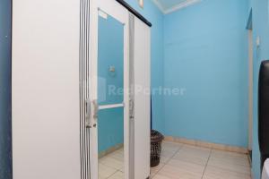 a door into a room with a blue wall at Fajar Inn Mitra RedDoorz in Jakarta
