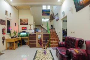 a living room with a couch and a fish tank at Fajar Inn Mitra RedDoorz in Jakarta