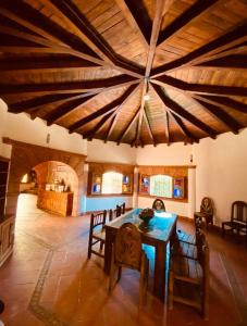 a dining room with a table and a large ceiling at Casa estilo Campirano Jardín de los Soles in Taxco de Alarcón