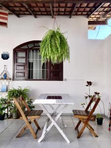 una mesa y dos sillas en un patio con una planta en Odoyá Casa Hostel en Arraial d'Ajuda