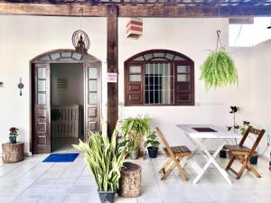 un patio con tavolo e sedie di fronte a una casa di Odoyá Casa Hostel a Arraial d'Ajuda