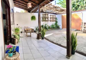 um pátio exterior com plantas e uma mesa em Odoyá Casa Hostel em Arraial d'Ajuda