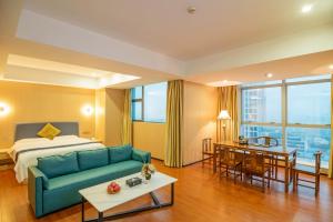ein Hotelzimmer mit einem Sofa und einem Bett in der Unterkunft Green Island Holiday Hotel in Jiangmen