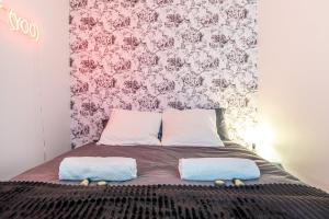 ein Bett mit zwei Kissen darauf mit Blumentapete in der Unterkunft GuestReady - Blue Nest near Le Parc des Princes in Boulogne-Billancourt