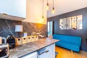 eine Küche mit blauem Sofa in einem Zimmer in der Unterkunft GuestReady - Blue Nest near Le Parc des Princes in Boulogne-Billancourt