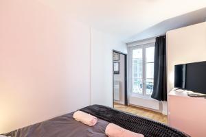 Schlafzimmer mit einem Bett und einem Flachbild-TV in der Unterkunft GuestReady - Blue Nest near Le Parc des Princes in Boulogne-Billancourt
