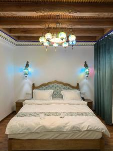 布哈拉的住宿－Istat Boutique Hotel，一间卧室配有一张带吊灯的大床