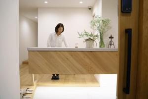 a woman standing behind a counter in a room at Hotel San Hiroshima in Hiroshima