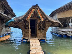 a small house in the water in the water at Bamboo Nest Beachfront in Puerto Princesa City