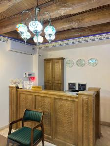 布哈拉的住宿－Istat Boutique Hotel，厨房设有1间带椅子和吊灯的酒吧