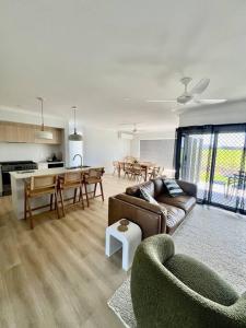 a living room with a couch and a table at Wait and Sea Bargara in Bargara