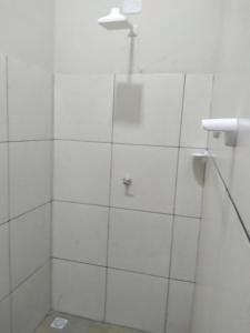 a bathroom with a shower with white tiled walls at Yanne chalé 1 in Barra Grande