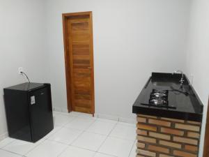 a kitchen with a stove and a refrigerator at Yanne chalé 1 in Barra Grande +10 photos