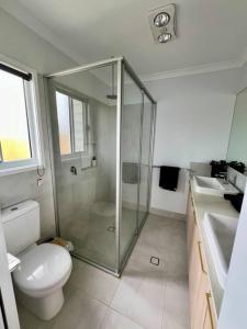 a bathroom with a shower and a toilet and a sink at Wait and Sea Bargara in Bargara