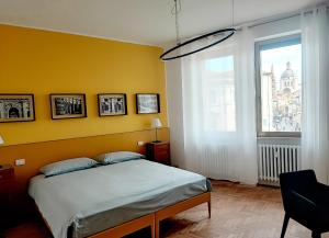 um quarto com uma cama e uma parede amarela em Foresteria Juvarra em Mantova