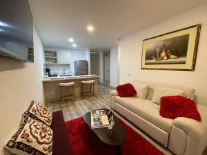 sala de estar con sofá y cocina en Comodo apartamento central en Manizales