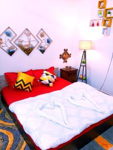 a bedroom with a red bed with pictures on the wall at JDreamland Homestay in Jorhāt