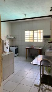 a large kitchen with a table and a refrigerator at Chácara jerivá in Boituva