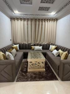 - un salon avec un canapé et une table dans l'établissement Family-sized Cosy Apartment, à Larache