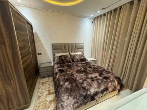 a bedroom with a bed with a brown blanket at Family-sized Cosy Apartment in Larache
