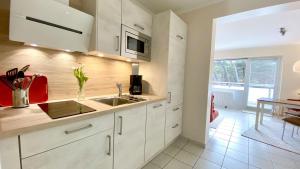 uma cozinha com armários brancos e um lavatório em Haus-Utlande-Whg-34 em Sankt Peter-Ording