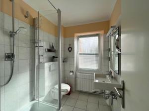 uma casa de banho com um chuveiro, um WC e um lavatório. em Haus-Utlande-Whg-34 em Sankt Peter-Ording