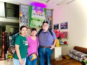 three people posing for a picture in a room at MyMy Motel in Da Nang