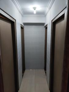 a hallway with two doors and a tile floor at Ega S Hostel in Nusa Penida