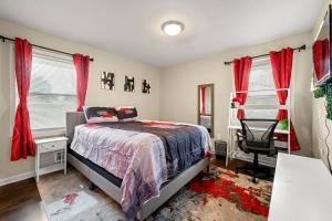 Schlafzimmer mit roten Vorhängen, einem Bett und einem Stuhl in der Unterkunft Big Red House in ATL by Hartsfield-Jackson Airport in Atlanta