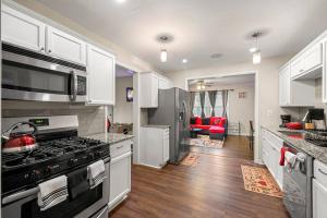 uma cozinha com armários brancos e um forno com placa de fogão em Big Red House in ATL by Hartsfield-Jackson Airport em Atlanta