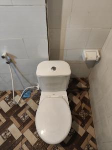 a bathroom with a white toilet in a room at Ega S Hostel in Nusa Penida